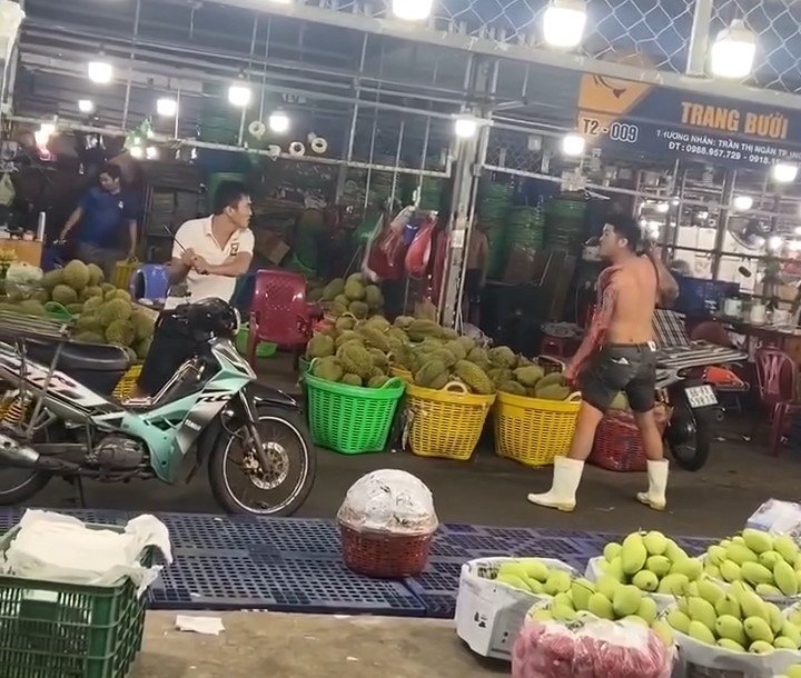 Hai người đàn ông đánh nhau bằng hung khí giữa chợ. Ảnh cắt từ clip